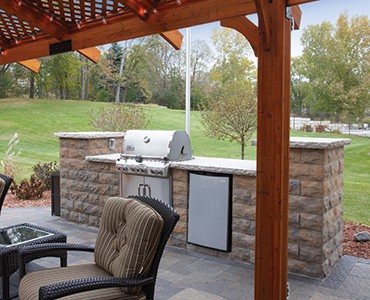 Freestanding stone retaining wall grilling station