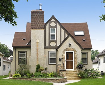 Front view of Tudor style home with Anchor Wall Natural Impressions flagstone raised planter