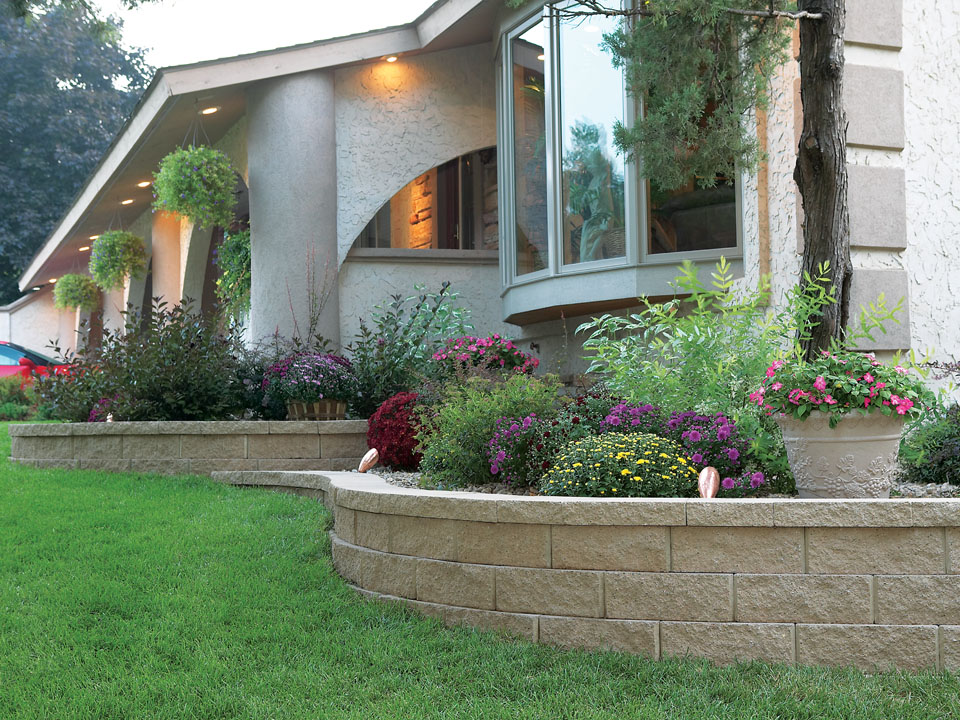 Modern stucco home with curved and terraced raised Diamond Pro straight face retaining wall planters