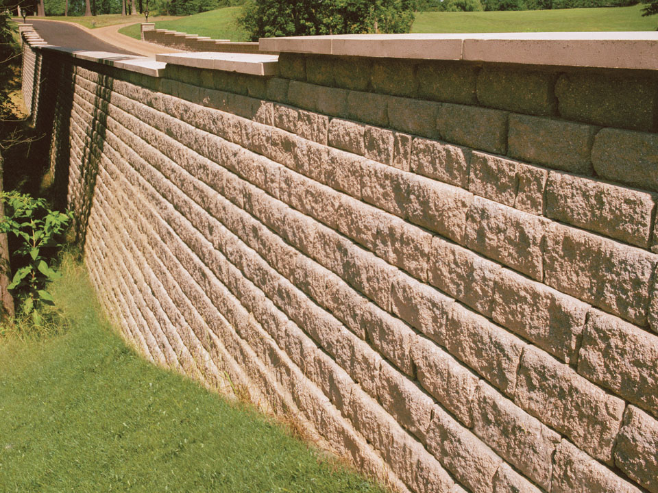 Close view of a curved Diamond Pro stone cut concrete block retaining wall planting area