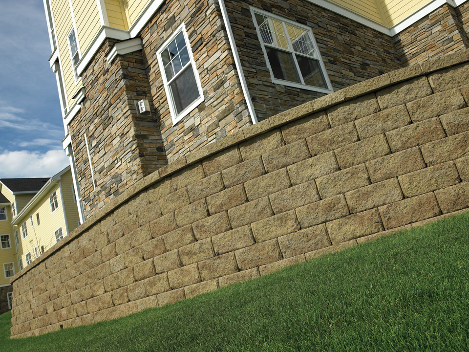 Close view of a curved and terraced Diamond Pro stone cut retaining wall with a planting area
