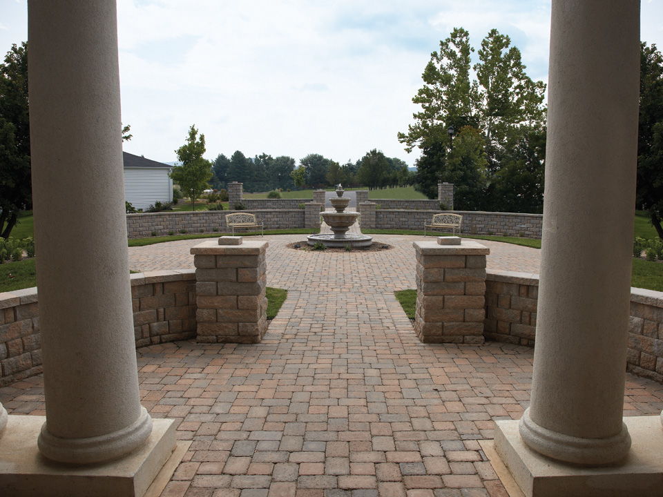 Stone paver fountain courtyard with round pillars and curved concrete block Highland Stone freestanding walls and columns