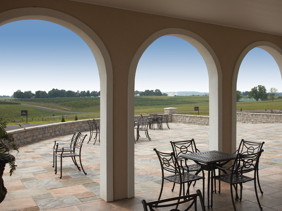 Three open arches leading to a curved patio surrounded by Highland Stone freestanding concrete block walls 