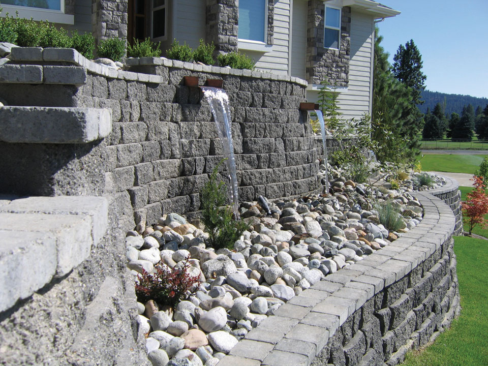 Close view of curved terraced waterfall feature made from Highland Stone concrete block retaining walls