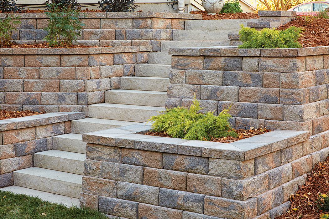 Landings Step Units set into a hill flanked by square raised concrete block retaining wall planters. 