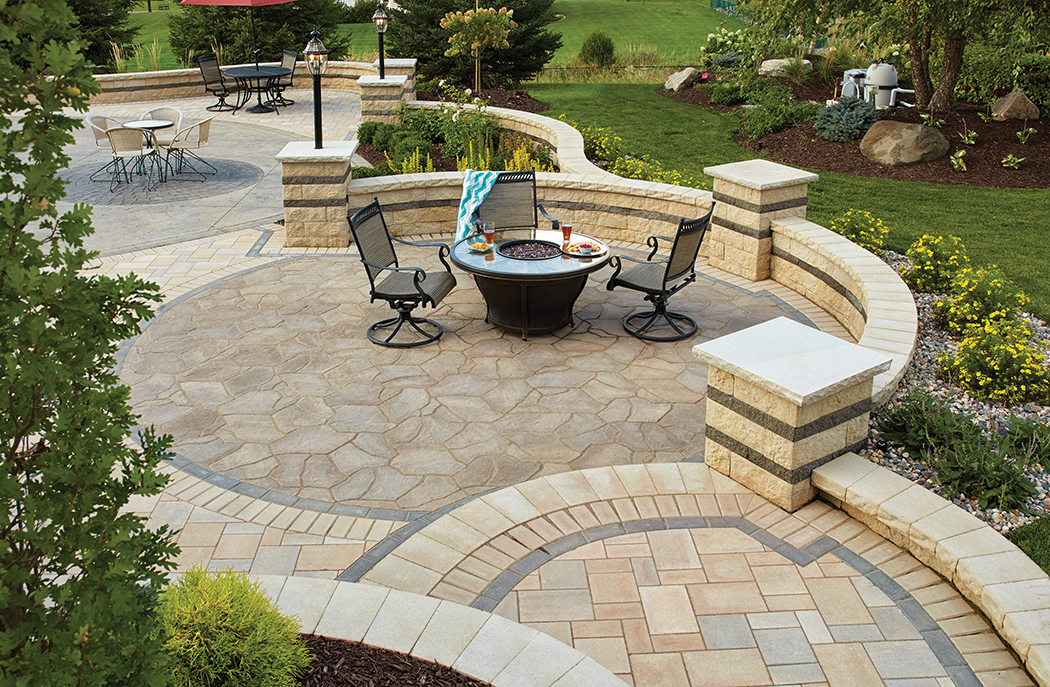 Circular paver patio with curved Matiz freestanding concrete block walls and columns, with inset planting area.