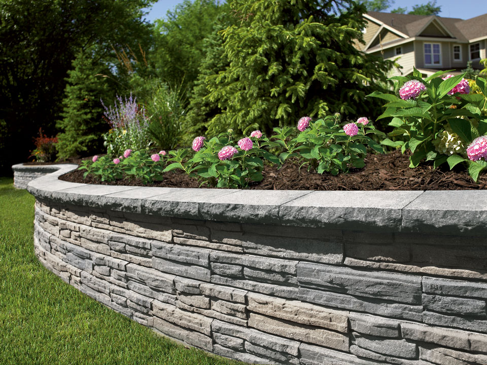 Close view of standalone raised circular Natural Impressions Flagstone concrete block retaining wall planter.