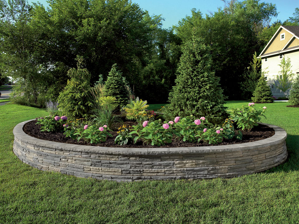 Standalone raised circular Natural Impressions Flagstone concrete block retaining wall planter.