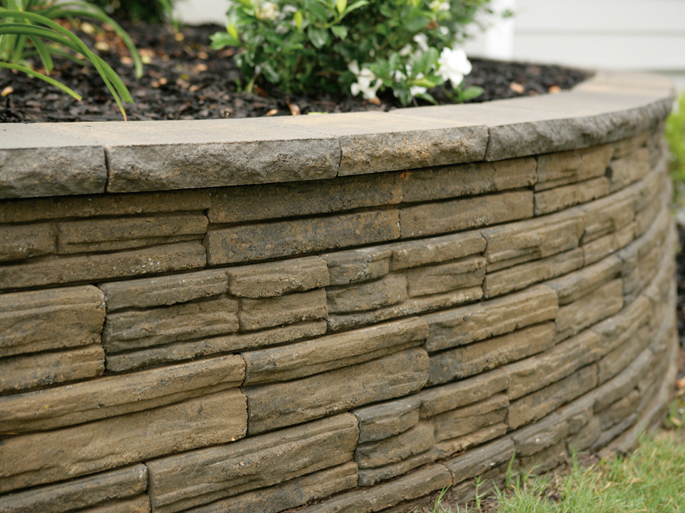 Close up view of a raised Natural Impressions Flagstone concrete block retaining wall planter. 